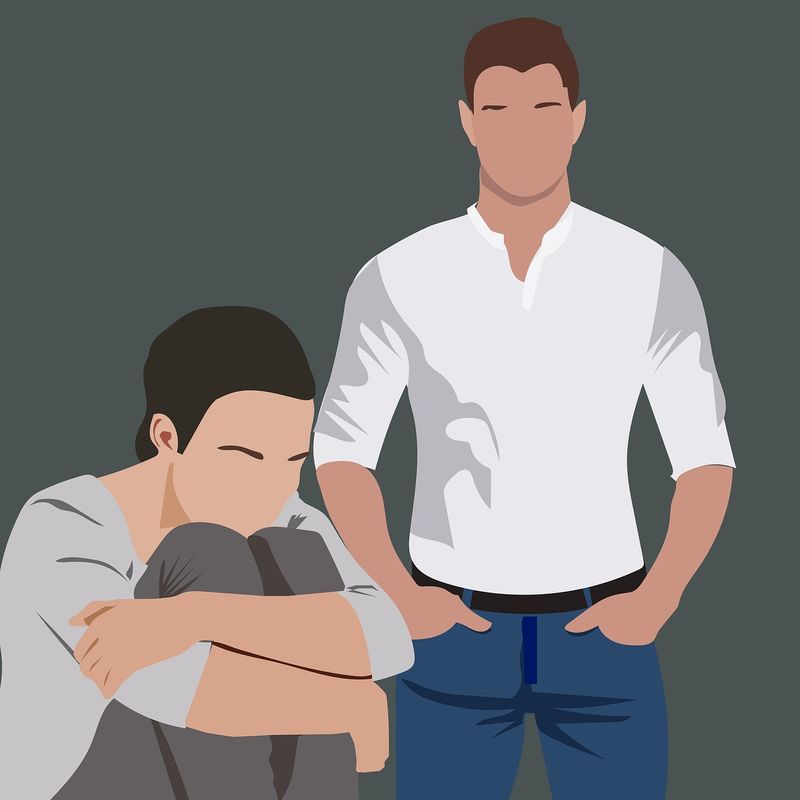 Illustration: Ein Mann steht dominant über einer zusammengekauerten Person